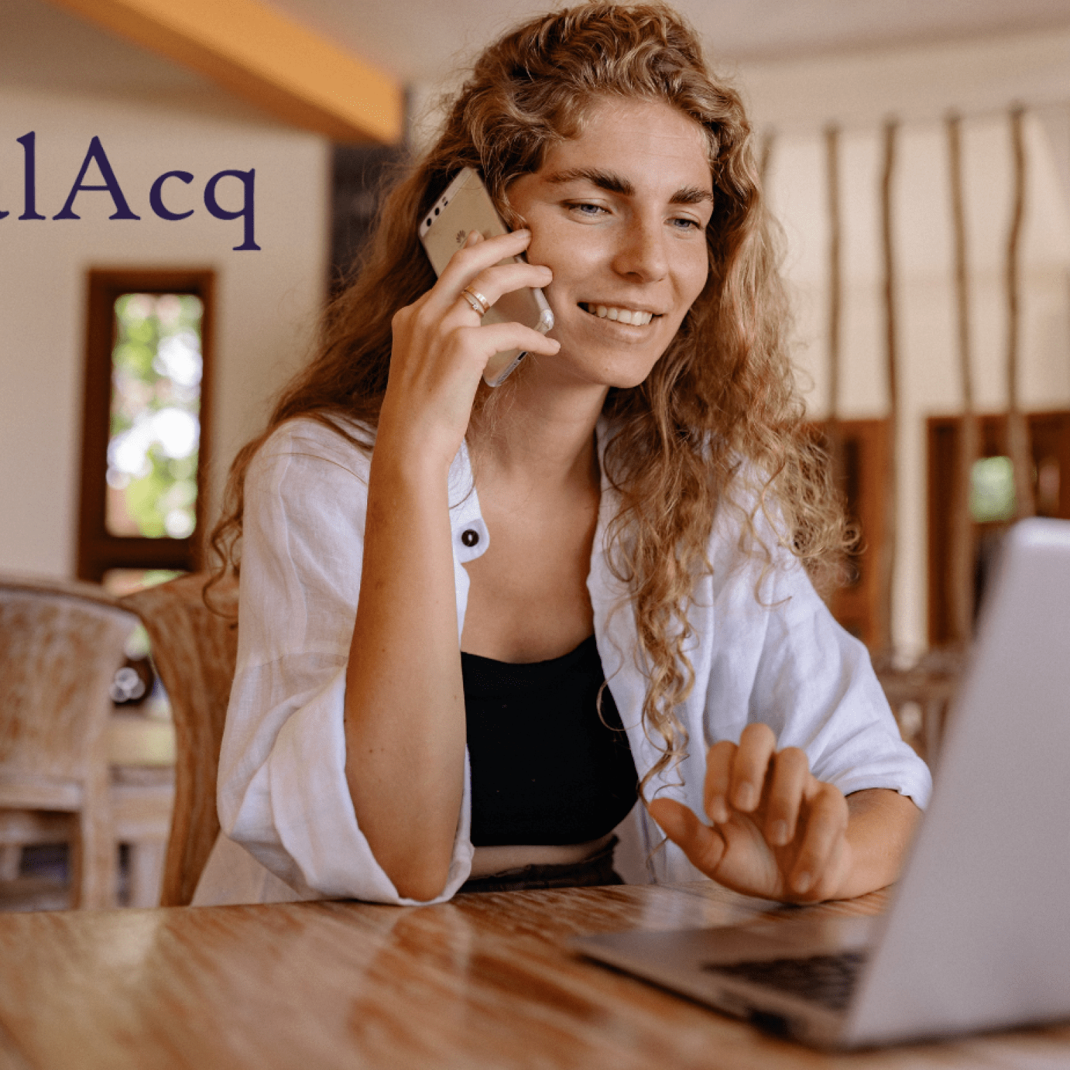 Lady working for home with phone in hand looking at laptop